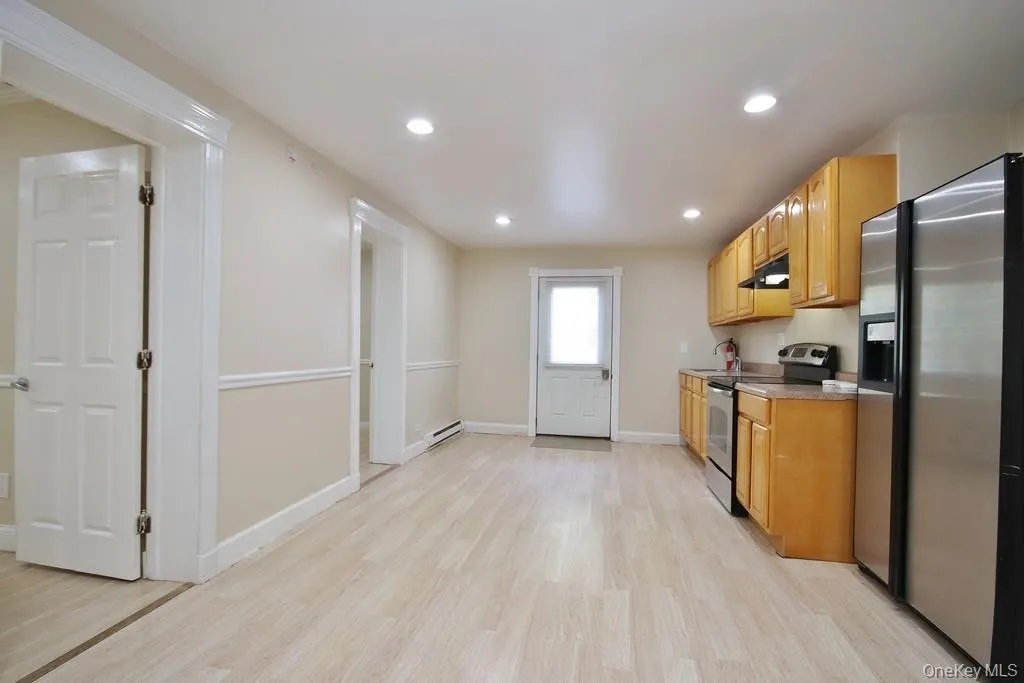 Kitchen with stainless steel appliances, recessed lighting, light wood-type flooring, light countertops, and under cabinet range hood Kitchen with stainless steel appliances, recessed lighting, light wood-type flooring, light countertops, and under cabinet range hood