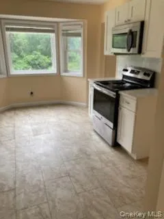 Kitchen with appliances with stainless steel finishes, white cabinetry, and light countertops Kitchen with appliances with stainless steel finishes, white cabinetry, and light countertops