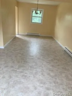 Unfurnished dining area with a baseboard radiator and a baseboard heating unit Unfurnished dining area with a baseboard radiator and a baseboard heating unit