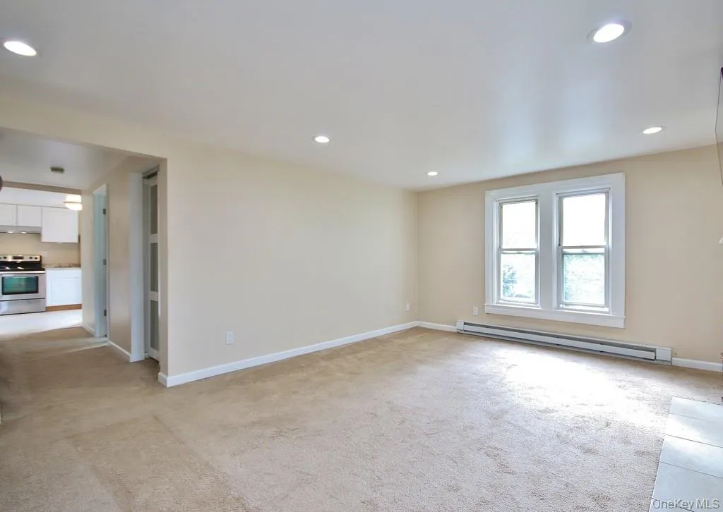 Unfurnished room with light carpet, a baseboard radiator, and recessed lighting Unfurnished room with light carpet, a baseboard radiator, and recessed lighting