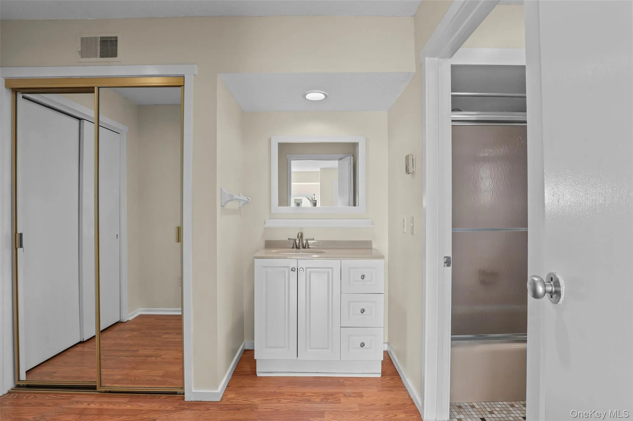 Full bath featuring vanity and light wood-style flooring Full bath featuring vanity and light wood-style flooring