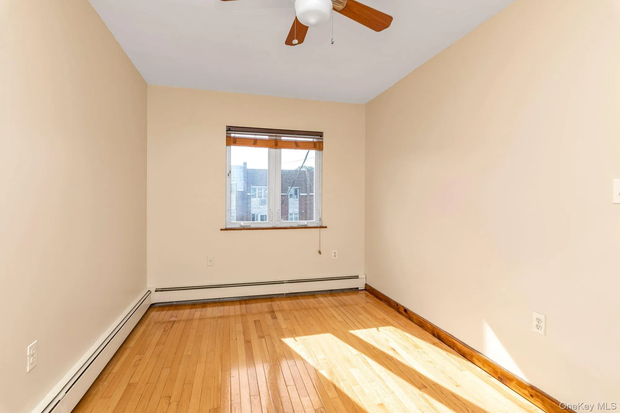 Spare room featuring baseboard heating, light wood finished floors, and ceiling fan Spare room featuring baseboard heating, light wood finished floors, and ceiling fan
