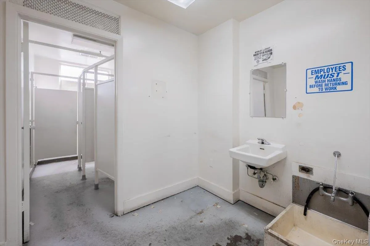 Bathroom with baseboards and concrete flooring Bathroom with baseboards and concrete flooring