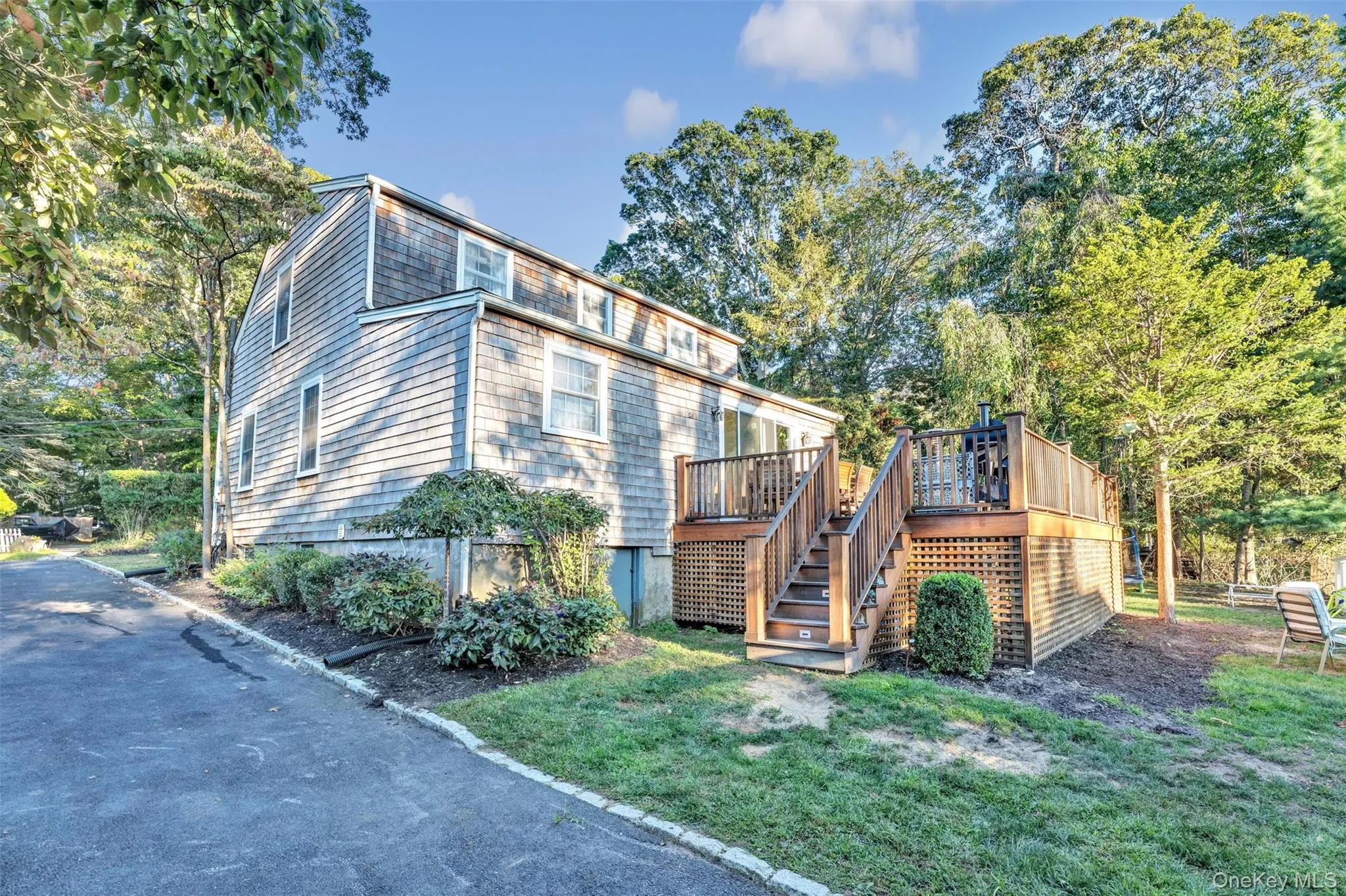Rear view of property with stairs, a deck, a lawn, and view of scattered trees Rear view of property with stairs, a deck, a lawn, and view of scattered trees
