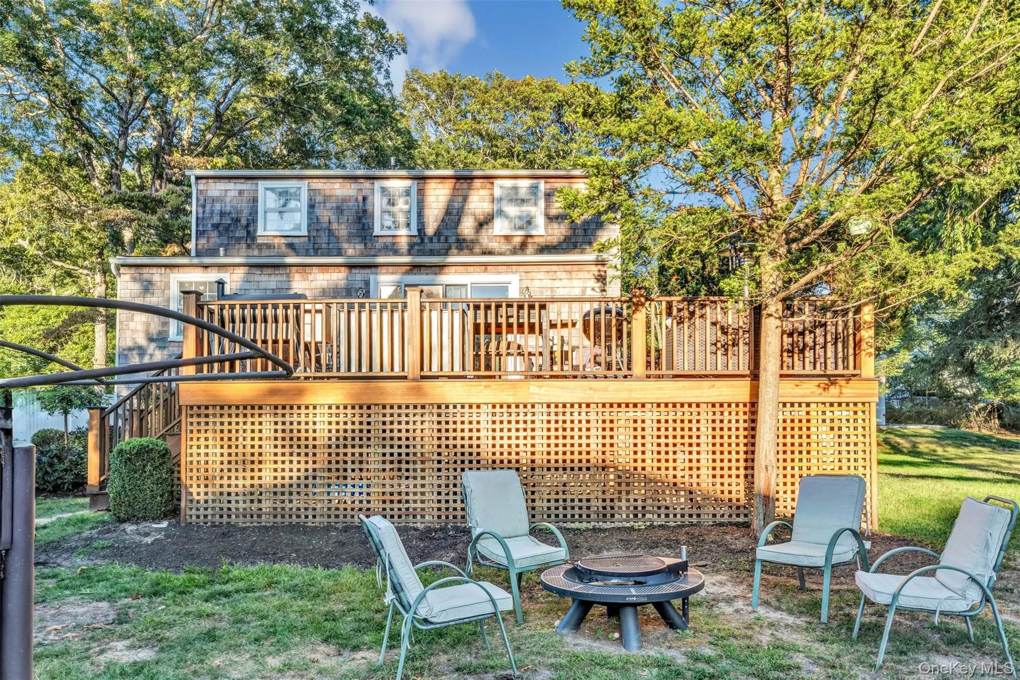Rear view of house featuring stairway, a deck, an outdoor fire pit, view of wooded area, and a yard Rear view of house featuring stairway, a deck, an outdoor fire pit, view of wooded area, and a yard
