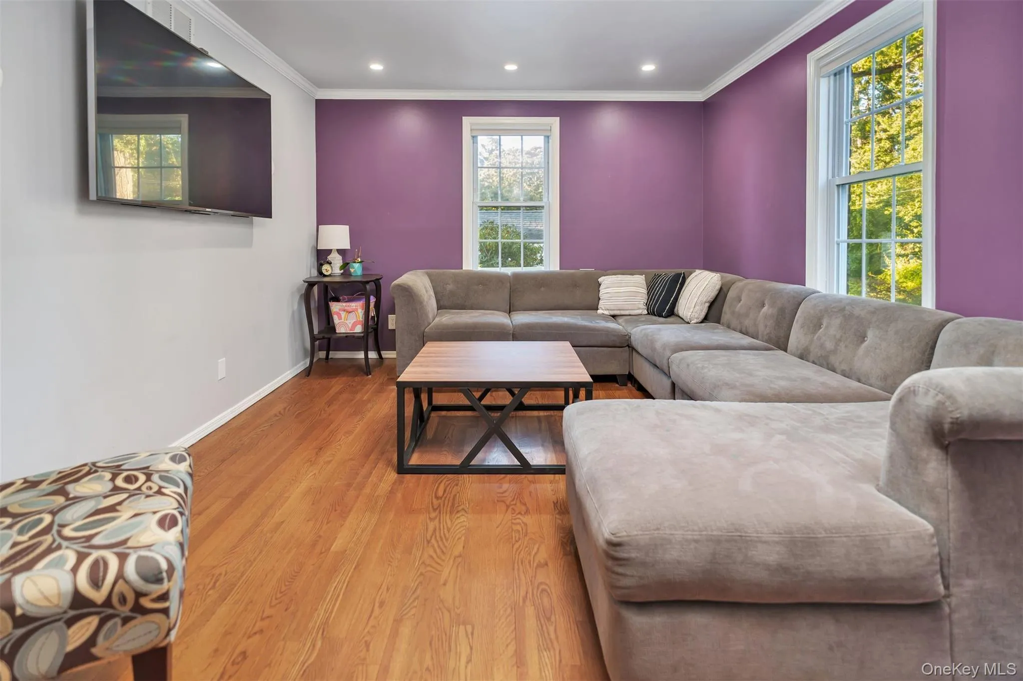 Living room featuring ornamental molding, wood finished floors, and recessed lighting Living room featuring ornamental molding, wood finished floors, and recessed lighting