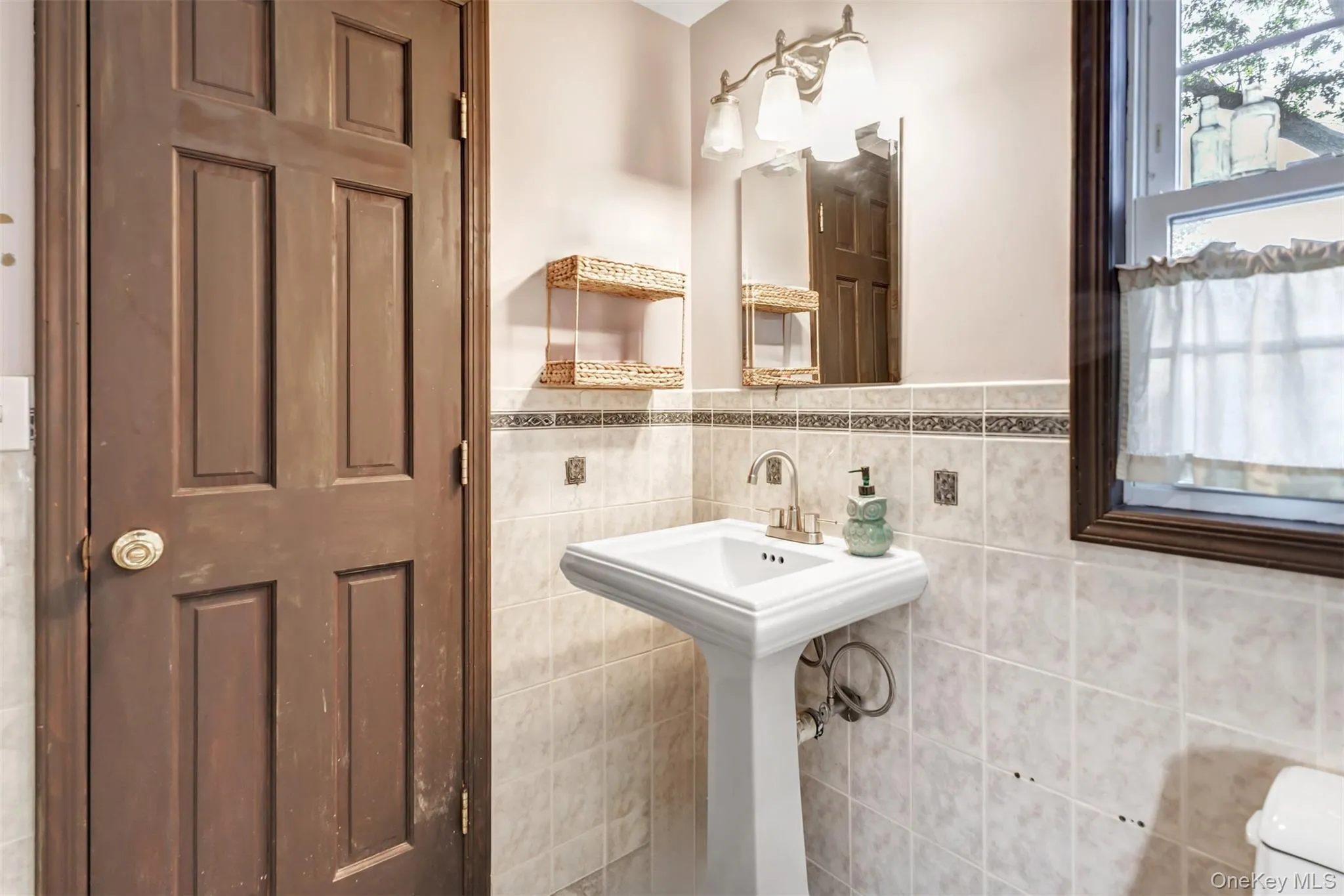 Bathroom featuring tile walls and a wainscoted wall Bathroom featuring tile walls and a wainscoted wall