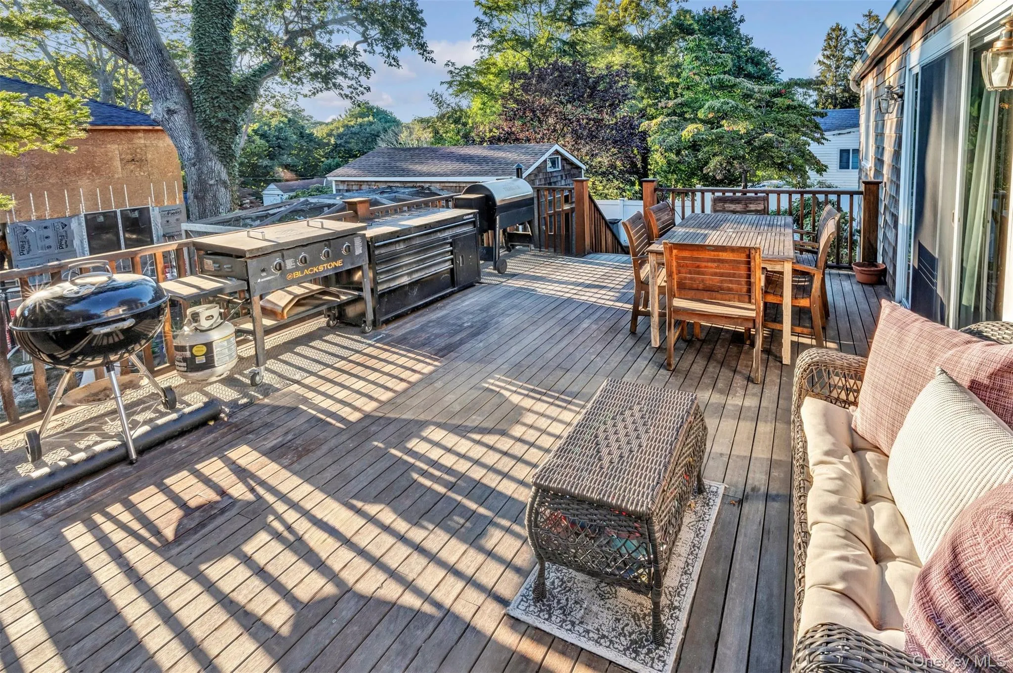 Wooden terrace with outdoor dining space and a grill Wooden terrace with outdoor dining space and a grill