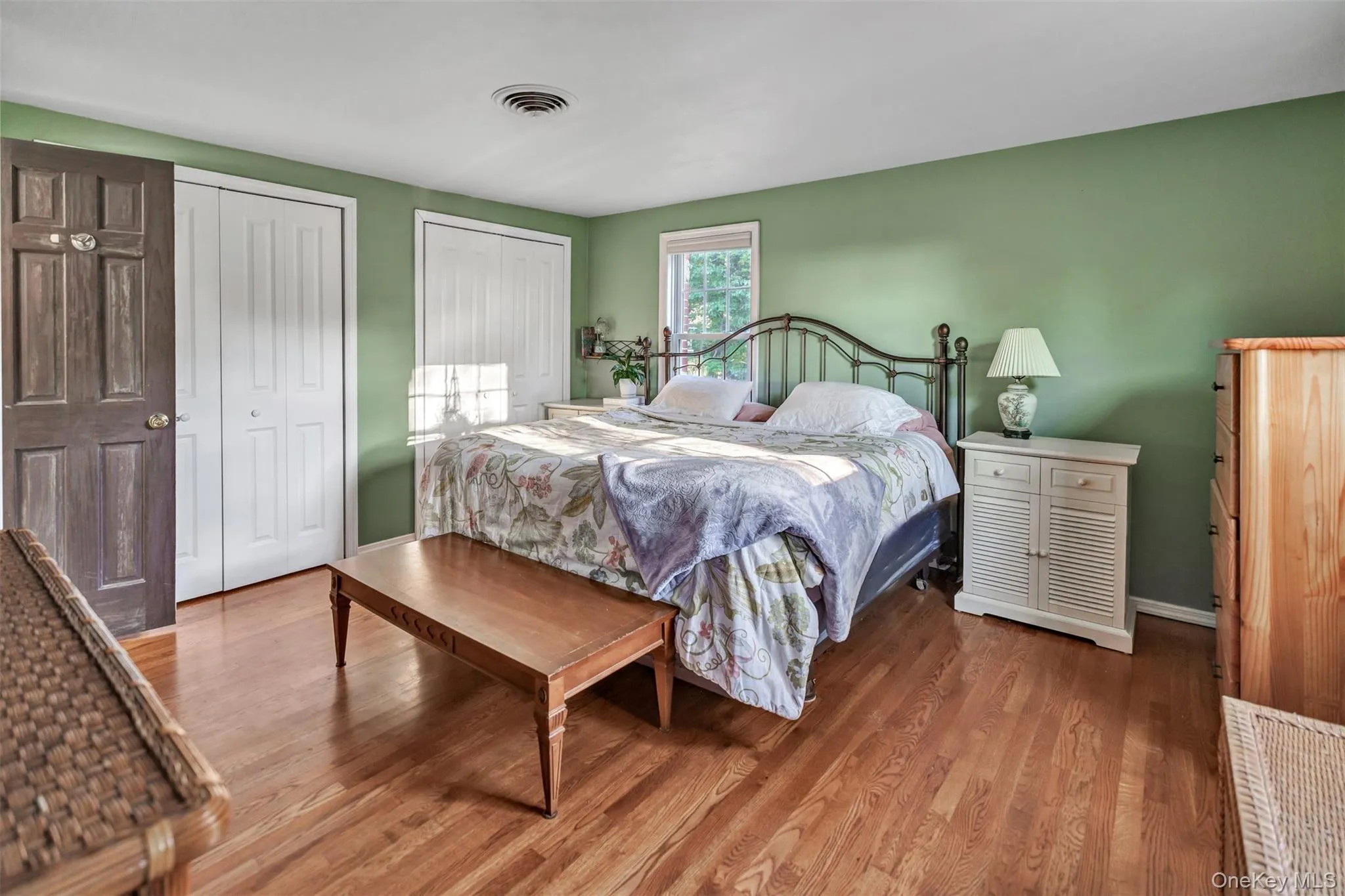 Primary Bedroom featuring two closets and wood finished floors Primary Bedroom featuring two closets and wood finished floors