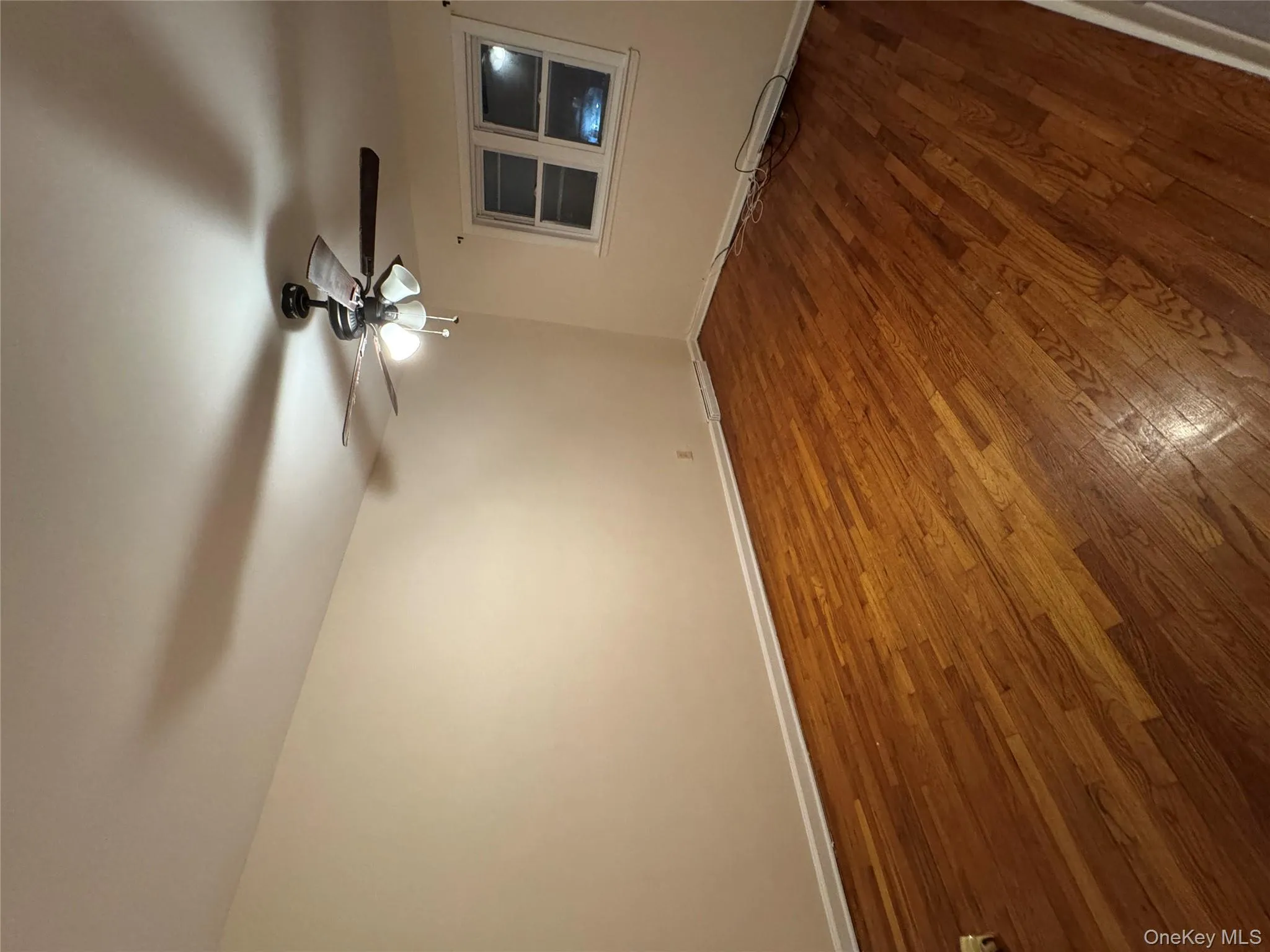 Unfurnished room featuring dark wood-style floors and a ceiling fan Unfurnished room featuring dark wood-style floors and a ceiling fan