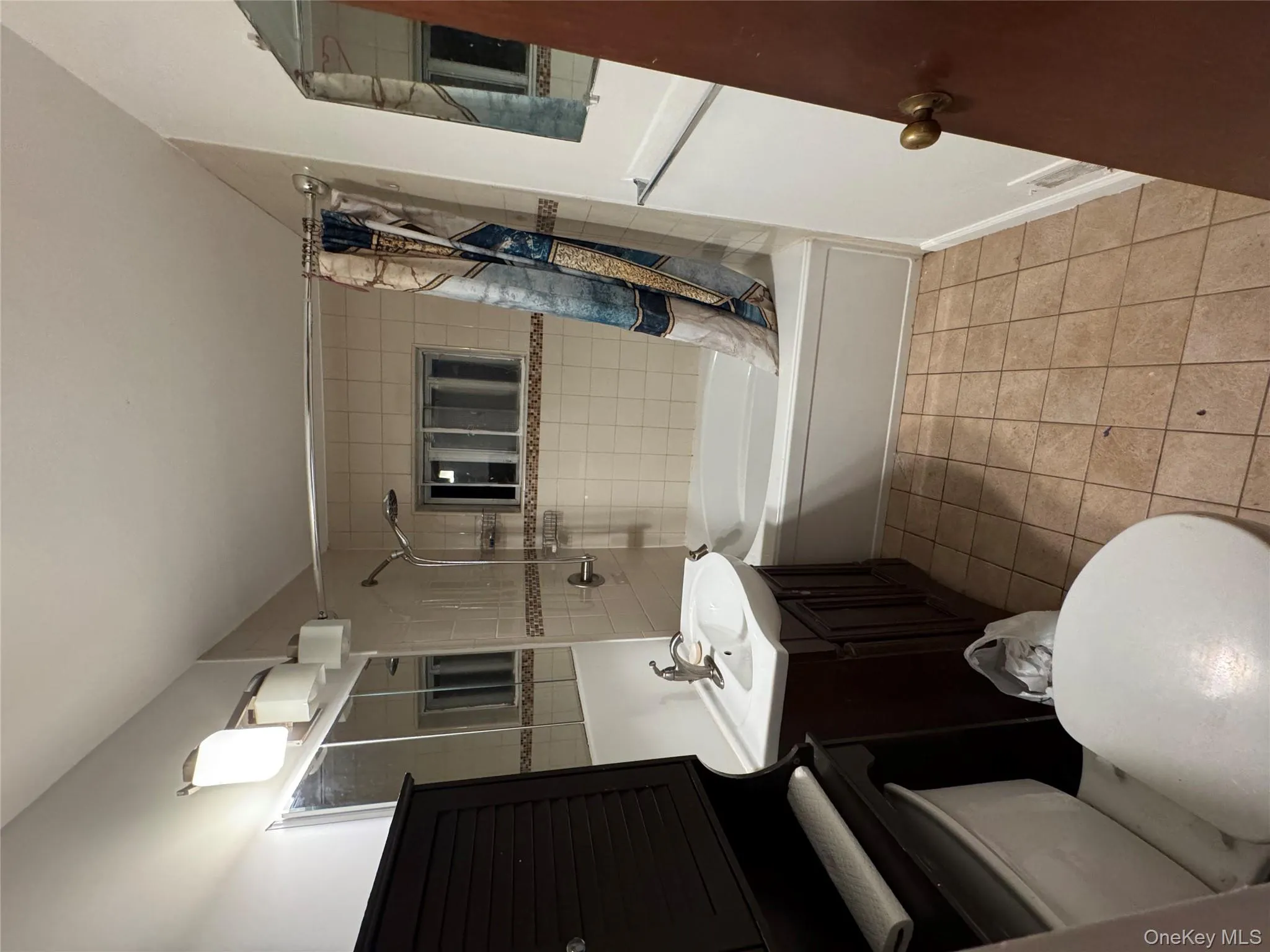 Full bathroom featuring shower / tub combo, light tile patterned floors, and vanity Full bathroom featuring shower / tub combo, light tile patterned floors, and vanity