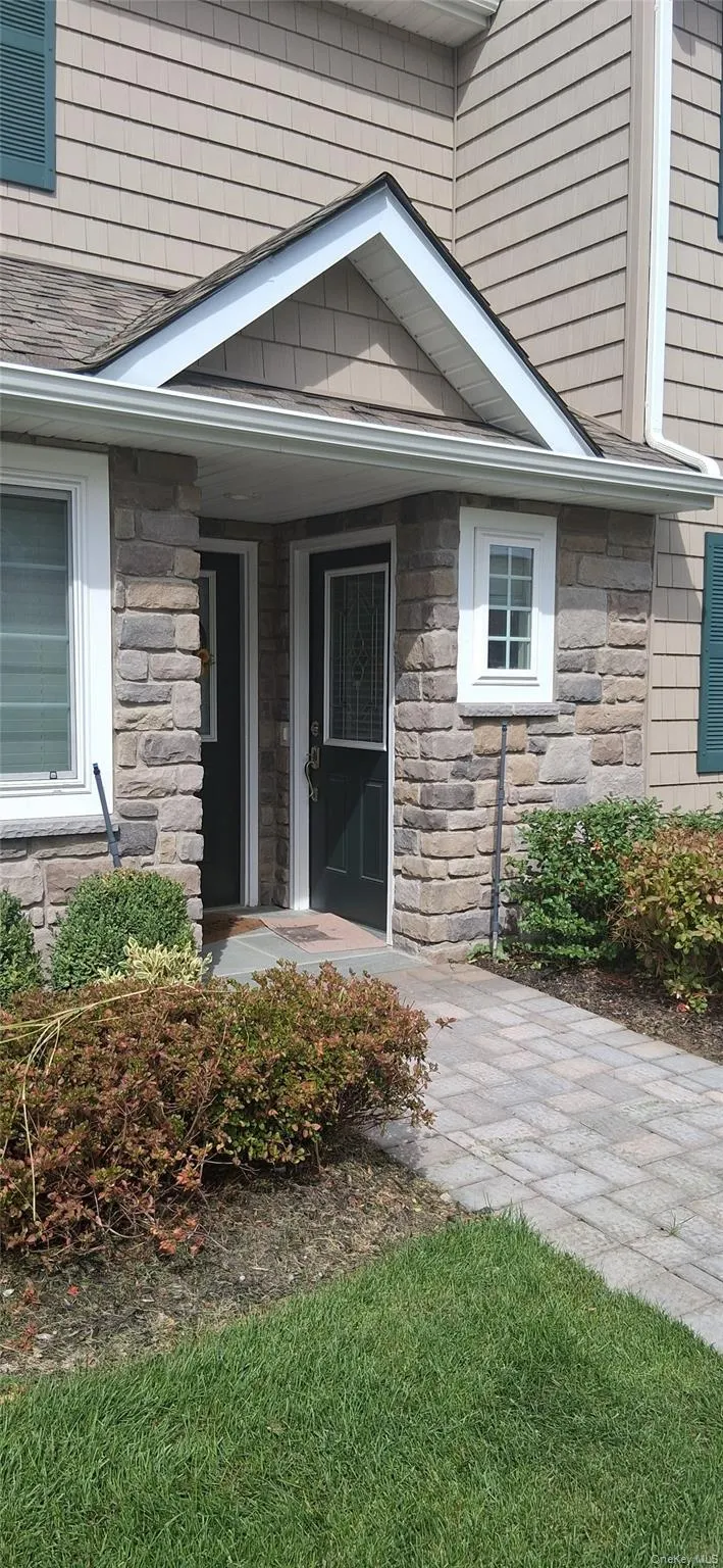 Doorway to property featuring stone siding and covered porch Doorway to property featuring stone siding and covered porch