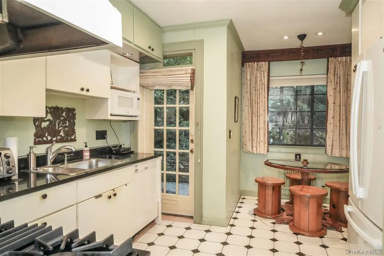 Kitchen with under cabinet range hood, white appliances, light flooring, and white cabinets Kitchen with under cabinet range hood, white appliances, light flooring, and white cabinets