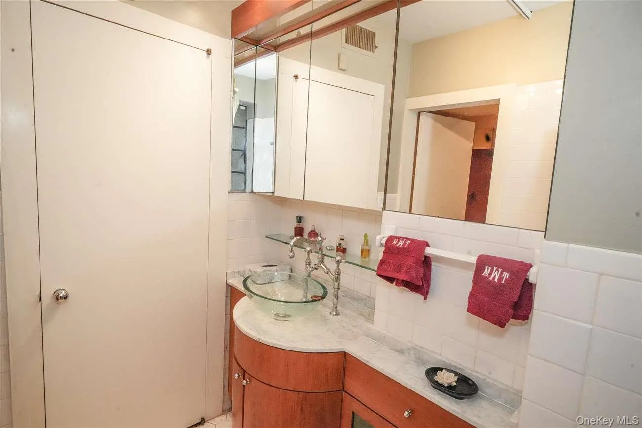 Half bathroom featuring backsplash, vanity, and tile walls Half bathroom featuring backsplash, vanity, and tile walls