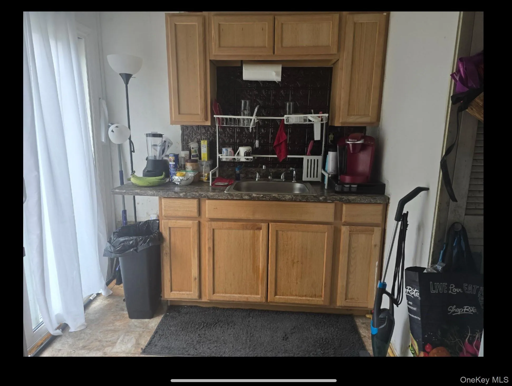 Kitchen featuring dark countertops and backsplash Kitchen featuring dark countertops and backsplash