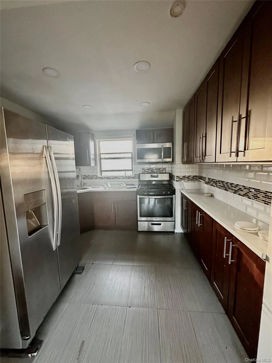 Kitchen featuring appliances with stainless steel finishes, tasteful backsplash, and dark brown cabinets Kitchen featuring appliances with stainless steel finishes, tasteful backsplash, and dark brown cabinets