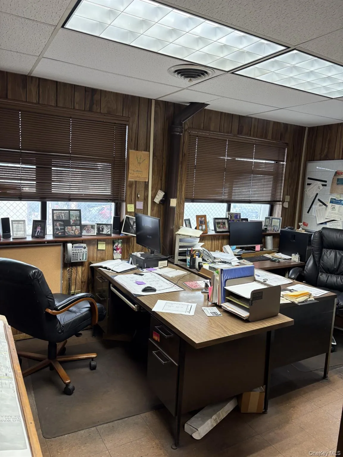 Office area with a drop ceiling and wooden walls Office area with a drop ceiling and wooden walls