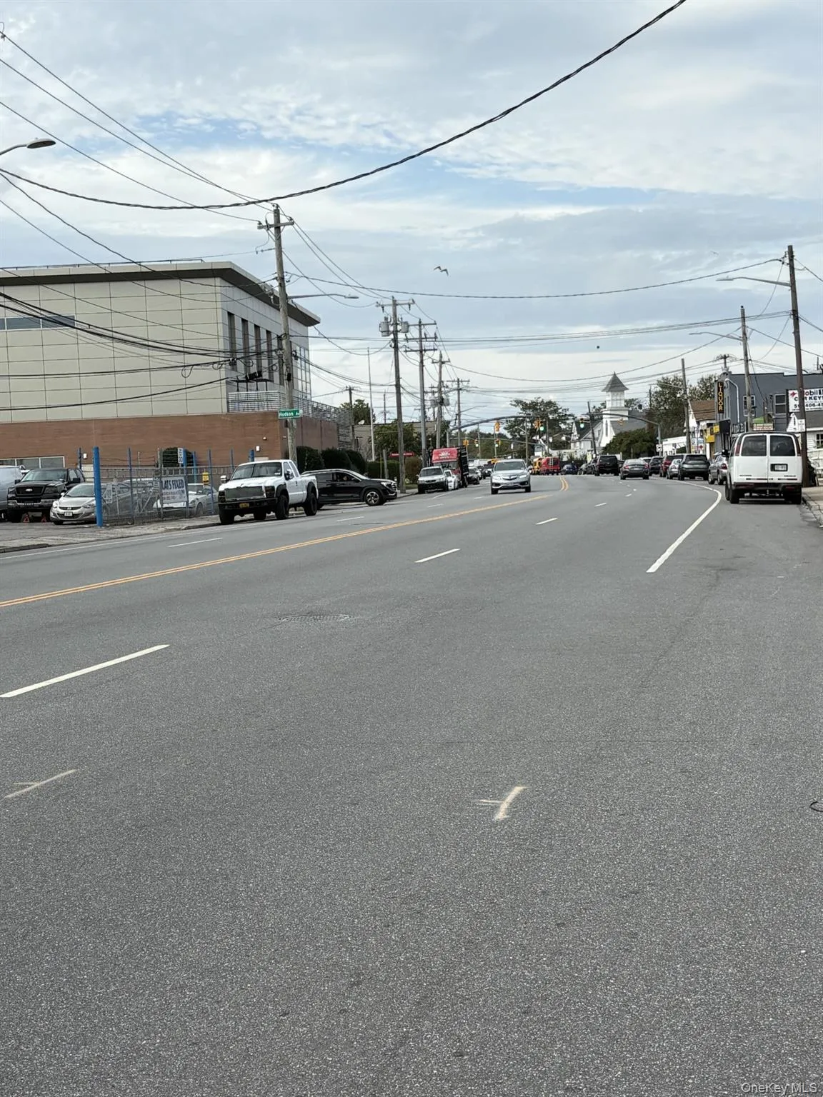 View of asphalt street featuring street lights and curbs View of asphalt street featuring street lights and curbs