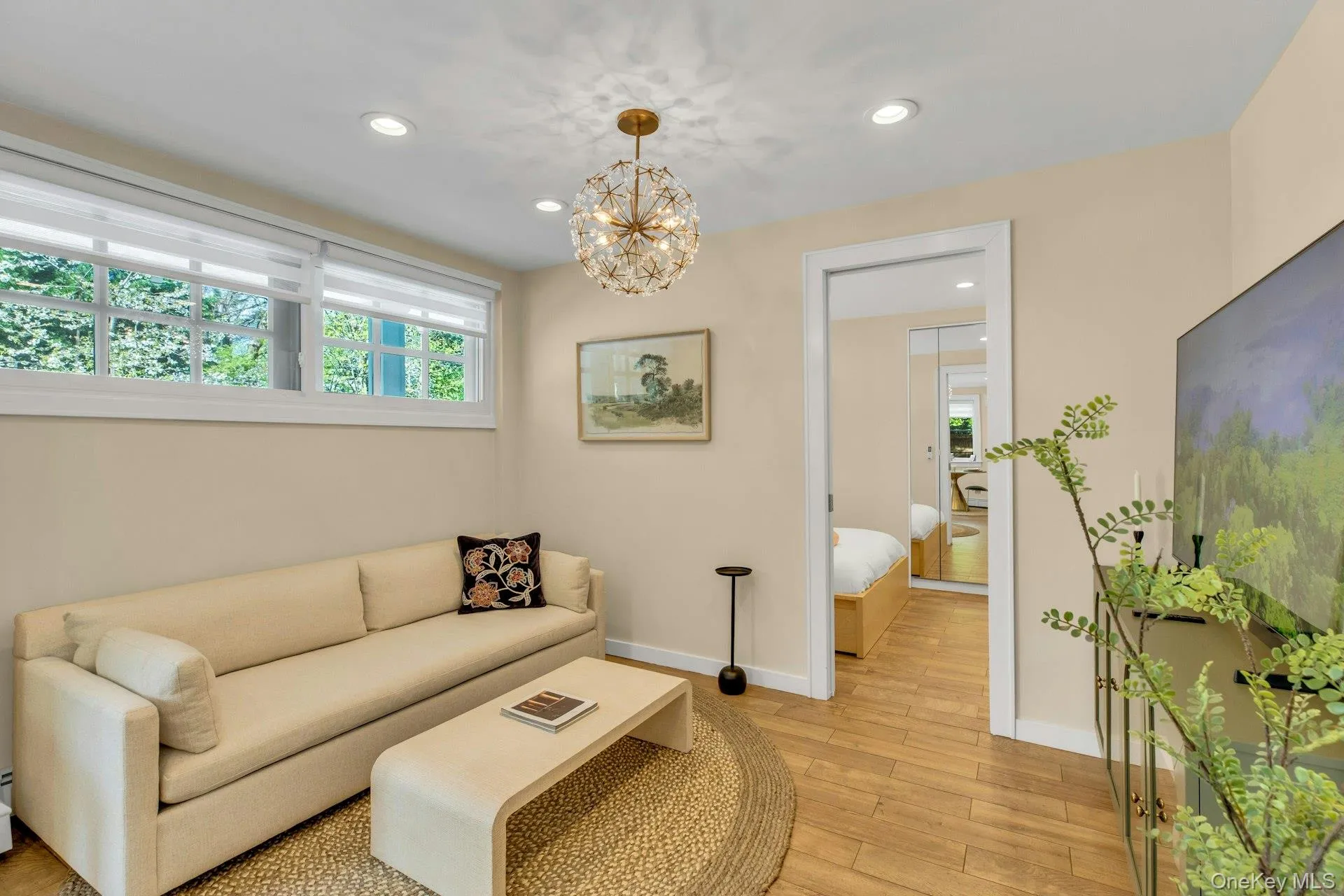 Living room featuring light floors, a chandelier, recessed lighting, and baseboards Living room featuring light floors, a chandelier, recessed lighting, and baseboards
