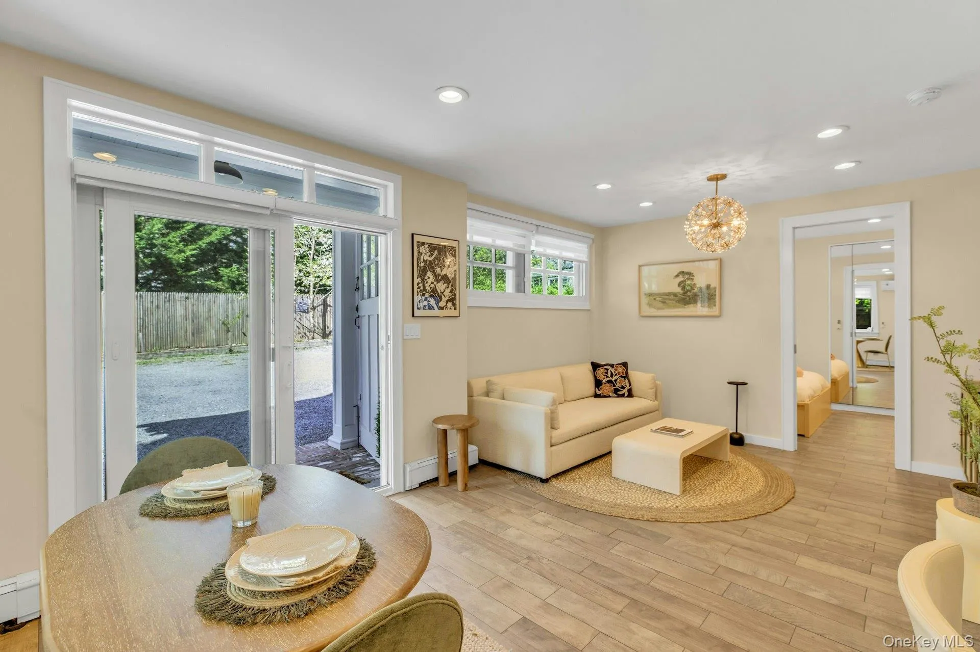 Living area featuring recessed lighting, a chandelier, baseboard heating, and baseboards Living area featuring recessed lighting, a chandelier, baseboard heating, and baseboards