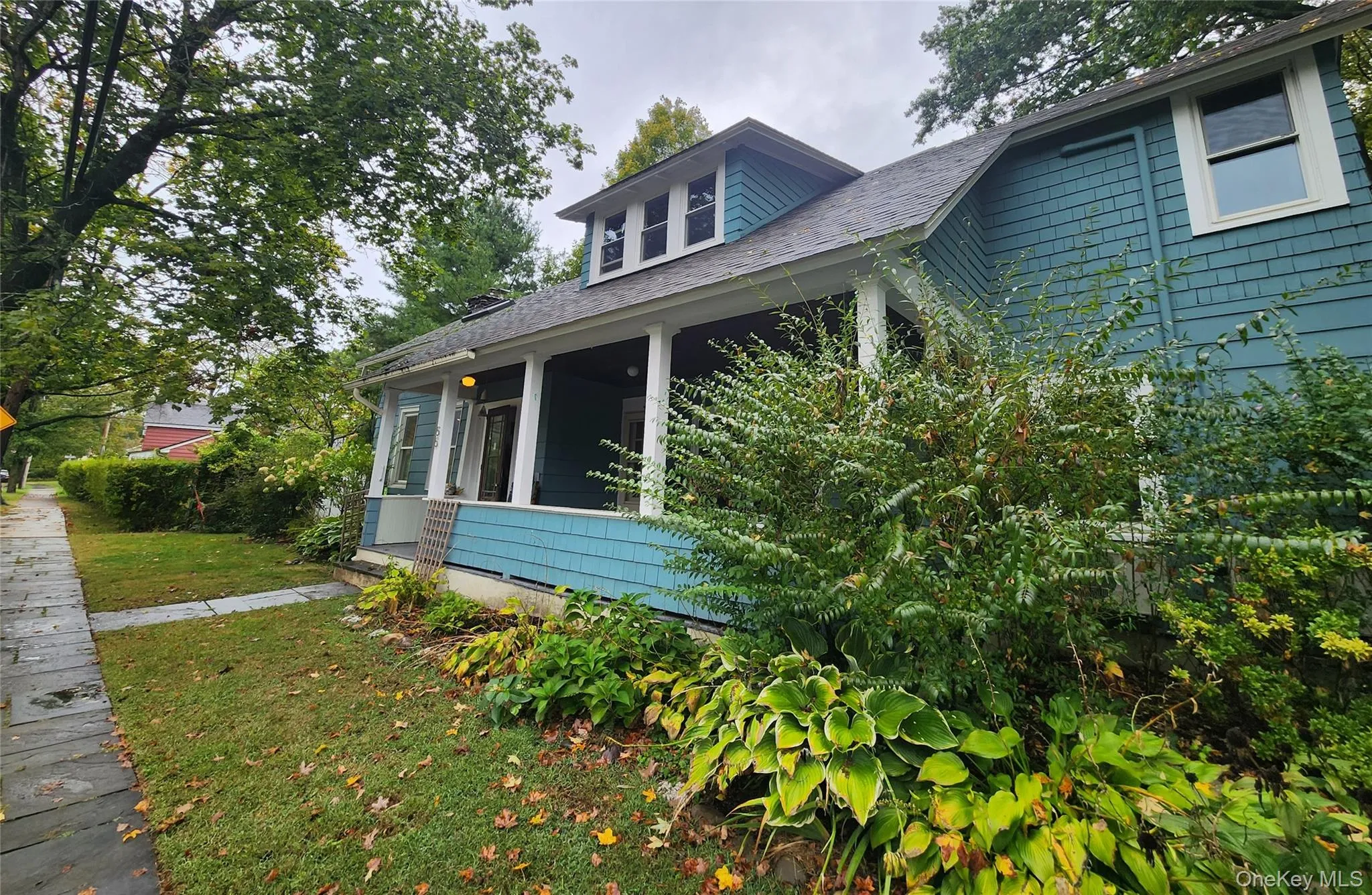 View of side of property featuring a sunroom, a yard, and a shingled roof View of side of property featuring a sunroom, a yard, and a shingled roof
