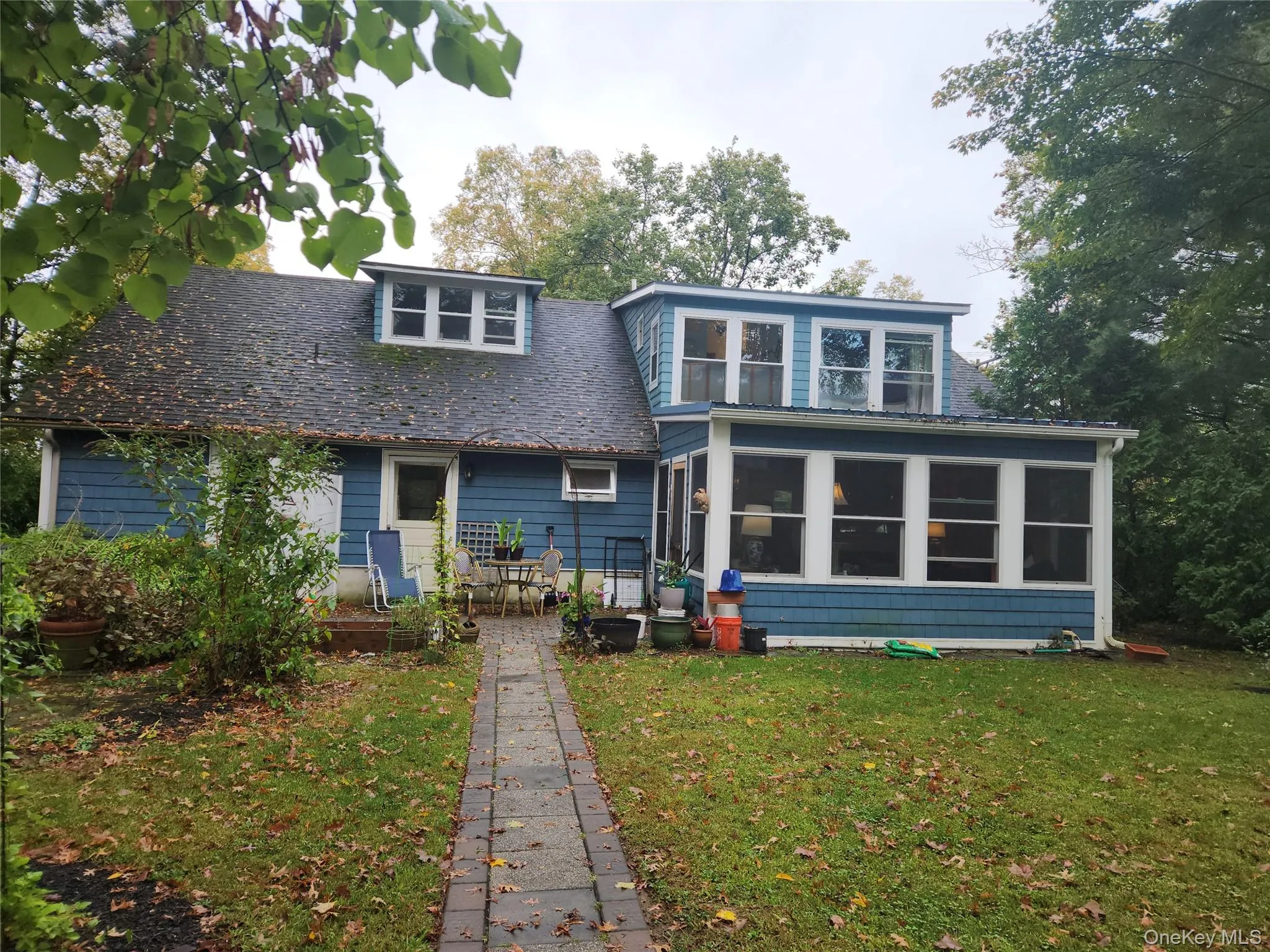 Rear view of property featuring a yard and a sunroom Rear view of property featuring a yard and a sunroom