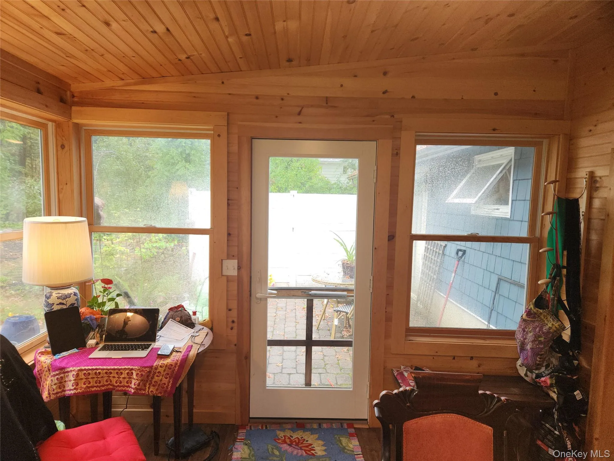 Doorway to outside featuring lofted ceiling, wooden walls, wooden ceiling, and healthy amount of natural light Doorway to outside featuring lofted ceiling, wooden walls, wooden ceiling, and healthy amount of natural light