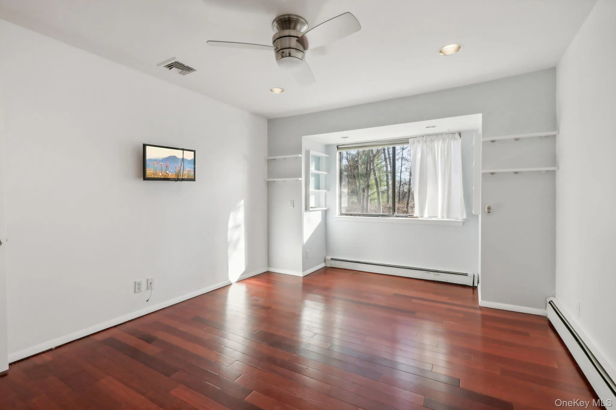 Unfurnished bedroom featuring a baseboard radiator, dark wood finished floors, a ceiling fan, and recessed lighting Unfurnished bedroom featuring a baseboard radiator, dark wood finished floors, a ceiling fan, and recessed lighting
