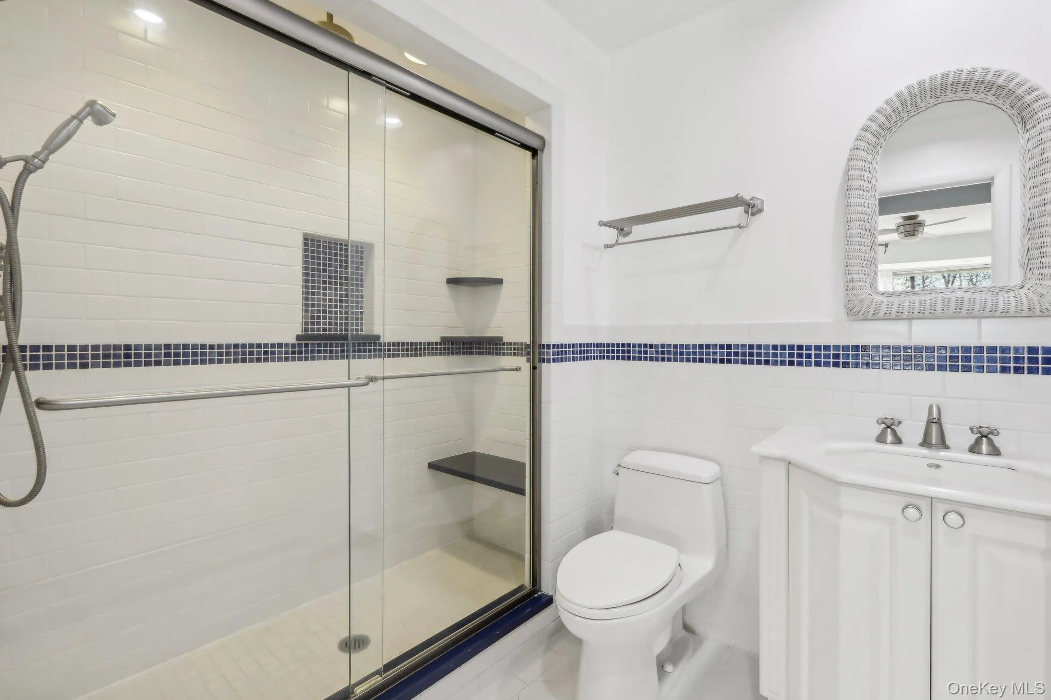 Full bath featuring vanity, a shower stall, and tile walls Full bath featuring vanity, a shower stall, and tile walls