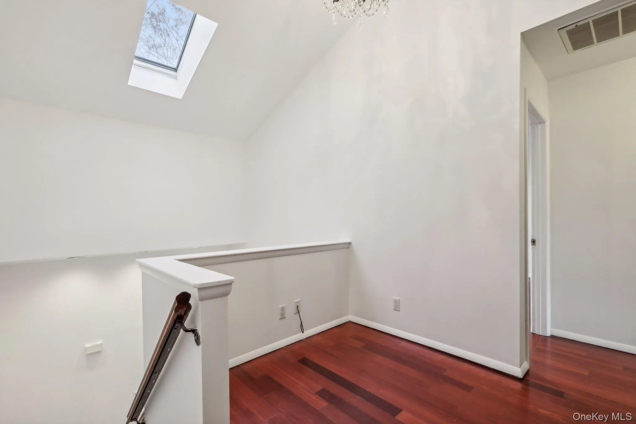 Additional living space with vaulted ceiling, dark wood-style flooring, and a skylight Additional living space with vaulted ceiling, dark wood-style flooring, and a skylight