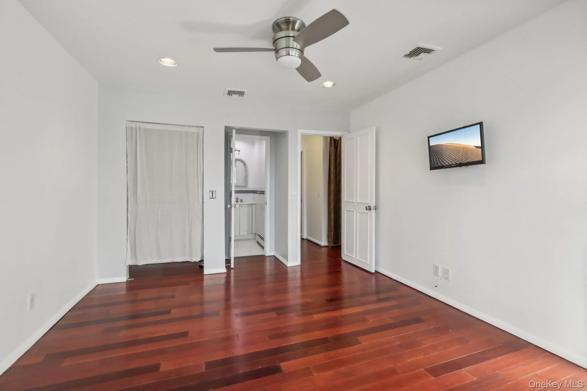 Unfurnished bedroom with a closet, ceiling fan, recessed lighting, and dark wood-style flooring Unfurnished bedroom with a closet, ceiling fan, recessed lighting, and dark wood-style flooring