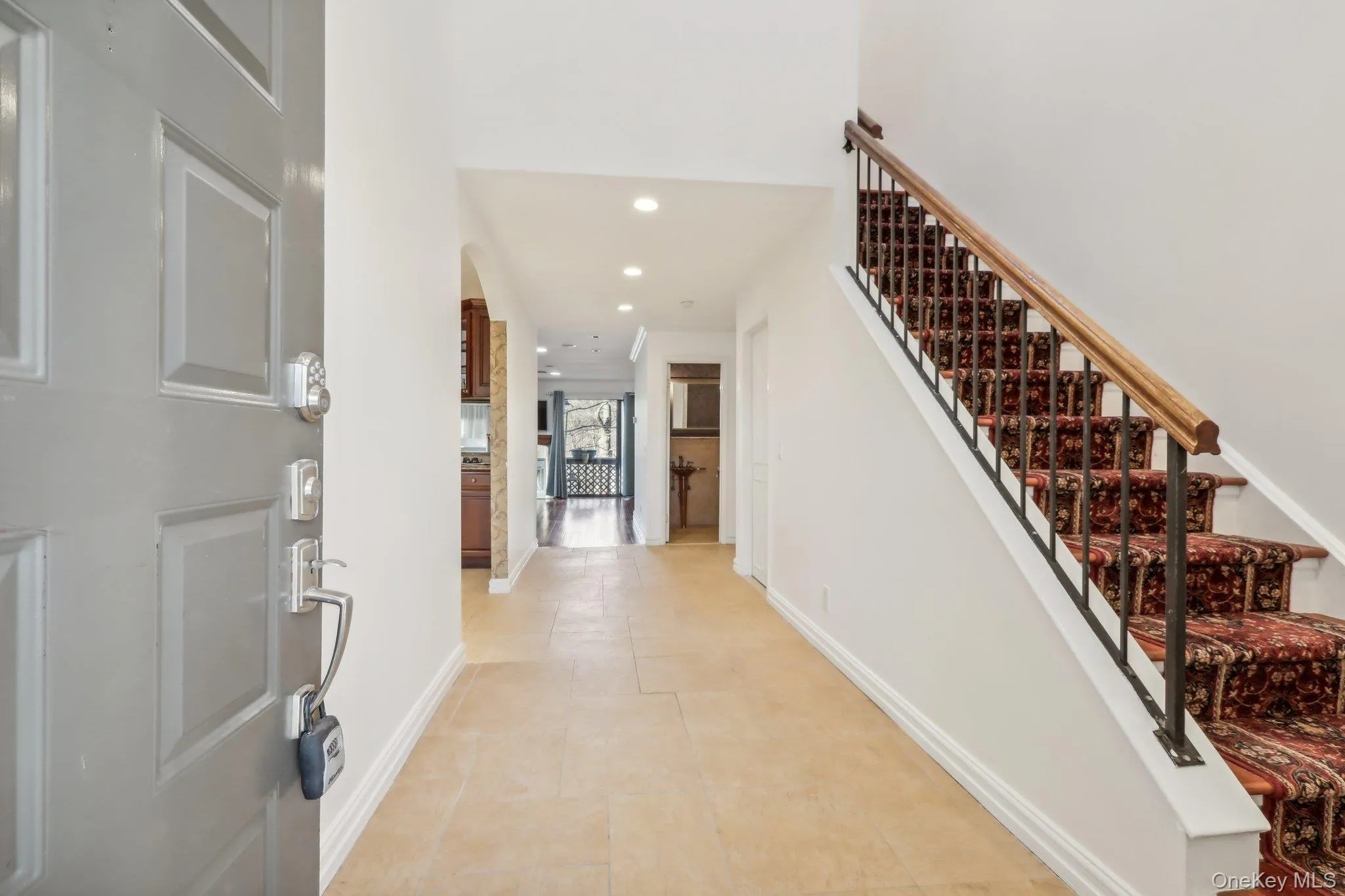 Entrance foyer with recessed lighting, stairs, arched walkways, and light tile patterned floors Entrance foyer with recessed lighting, stairs, arched walkways, and light tile patterned floors
