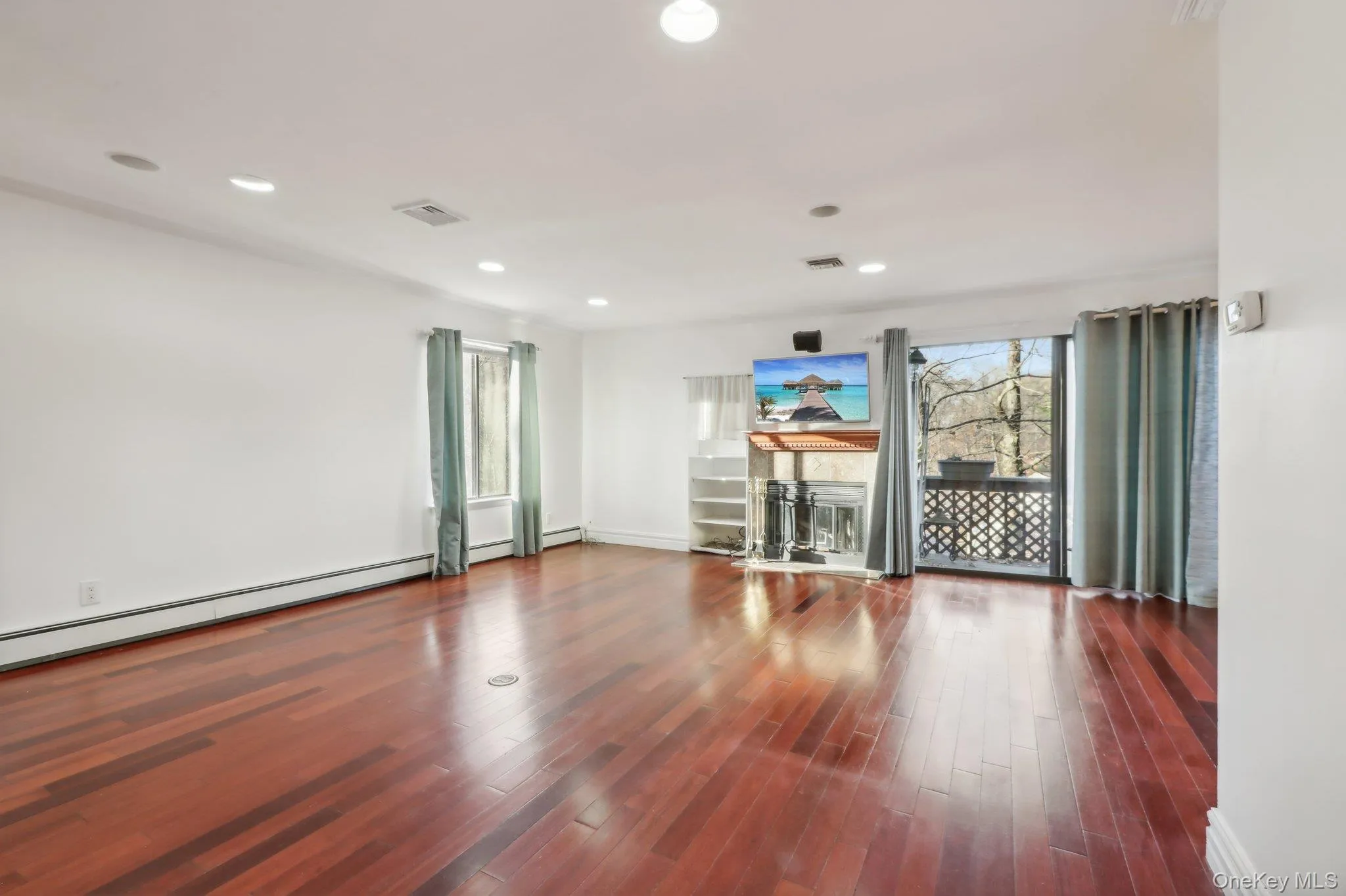 Spare room with wood finished floors, recessed lighting, and a baseboard heating unit Spare room with wood finished floors, recessed lighting, and a baseboard heating unit