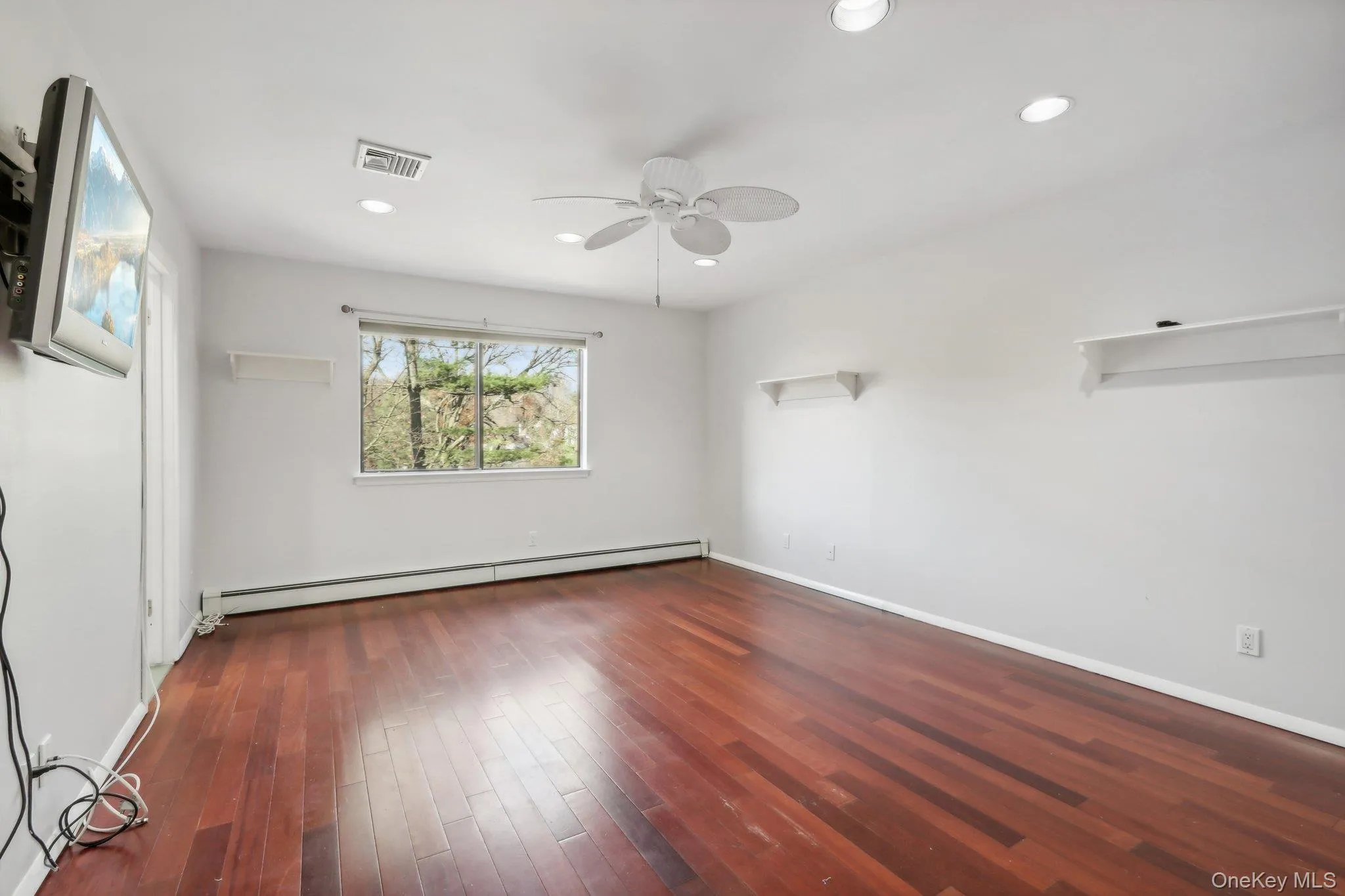 Unfurnished bedroom featuring dark wood finished floors, a baseboard radiator, ceiling fan, and recessed lighting Unfurnished bedroom featuring dark wood finished floors, a baseboard radiator, ceiling fan, and recessed lighting