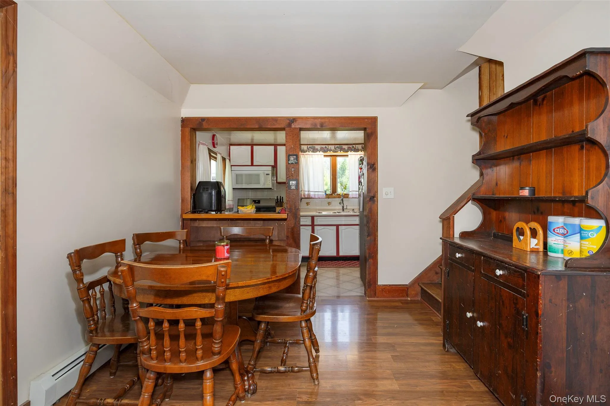 Dining space featuring wood finished floors and a baseboard heating unit Dining space featuring wood finished floors and a baseboard heating unit