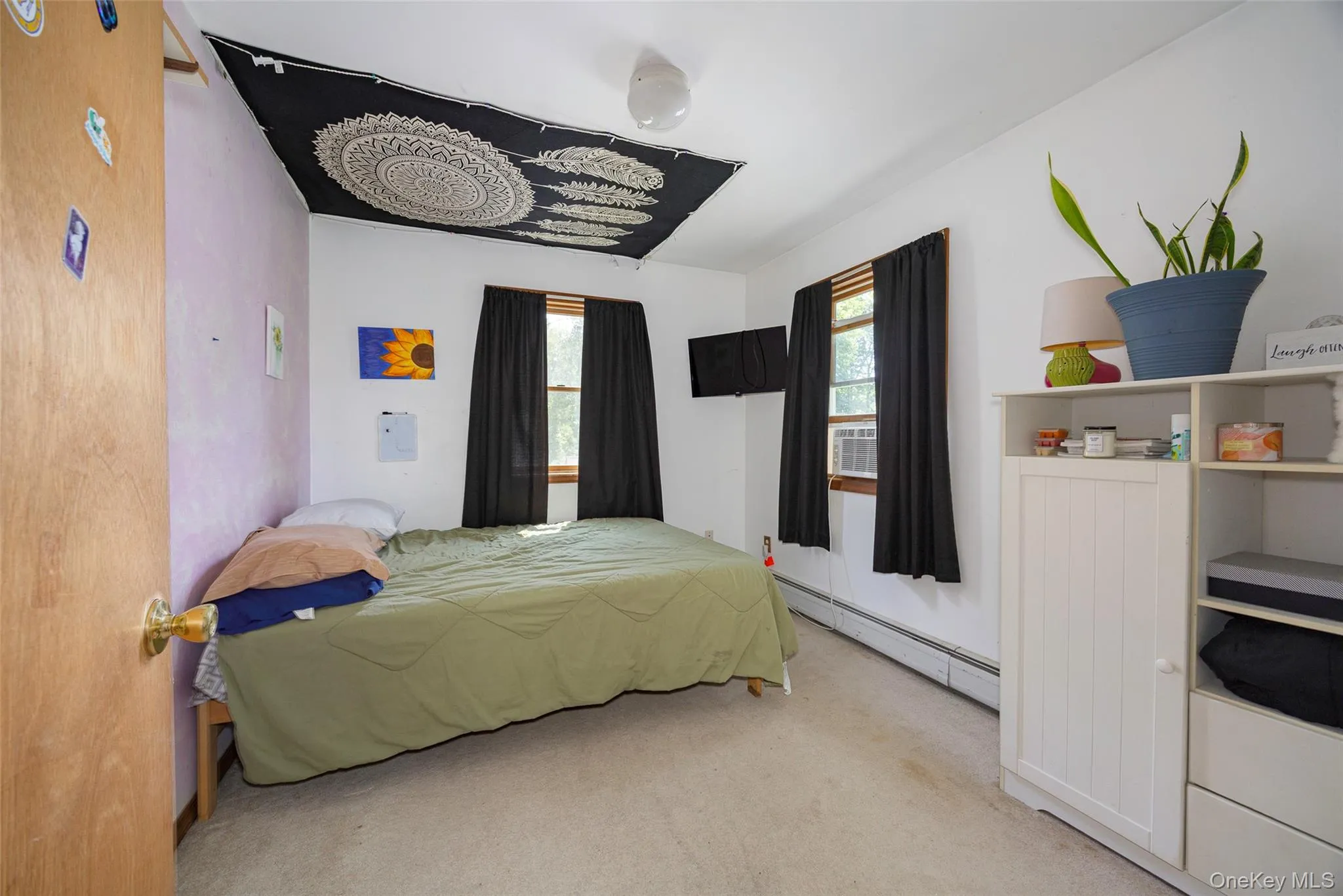 Bedroom with carpet and a baseboard heating unit Bedroom with carpet and a baseboard heating unit
