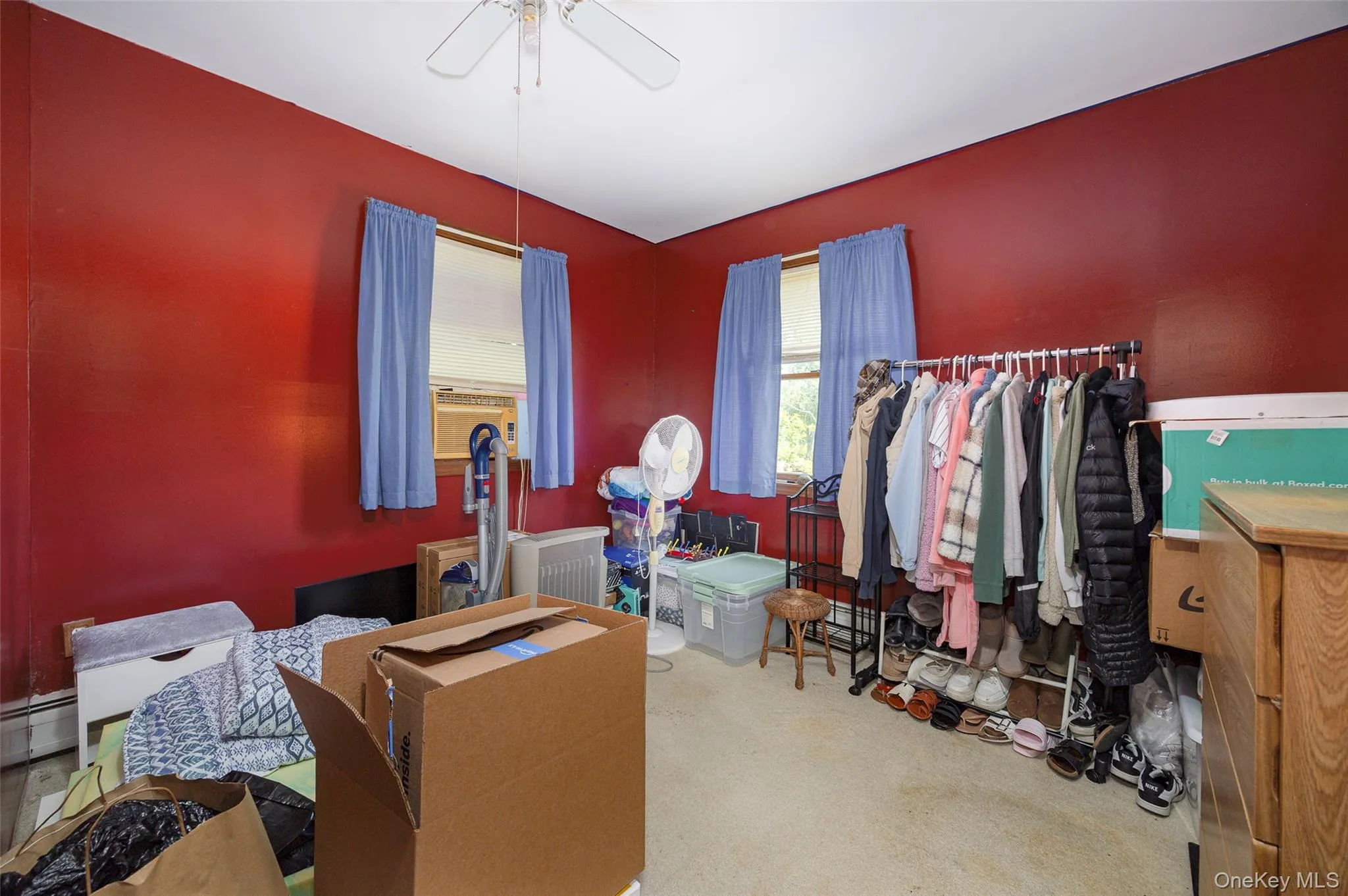Carpeted bedroom with a ceiling fan and a baseboard heating unit Carpeted bedroom with a ceiling fan and a baseboard heating unit