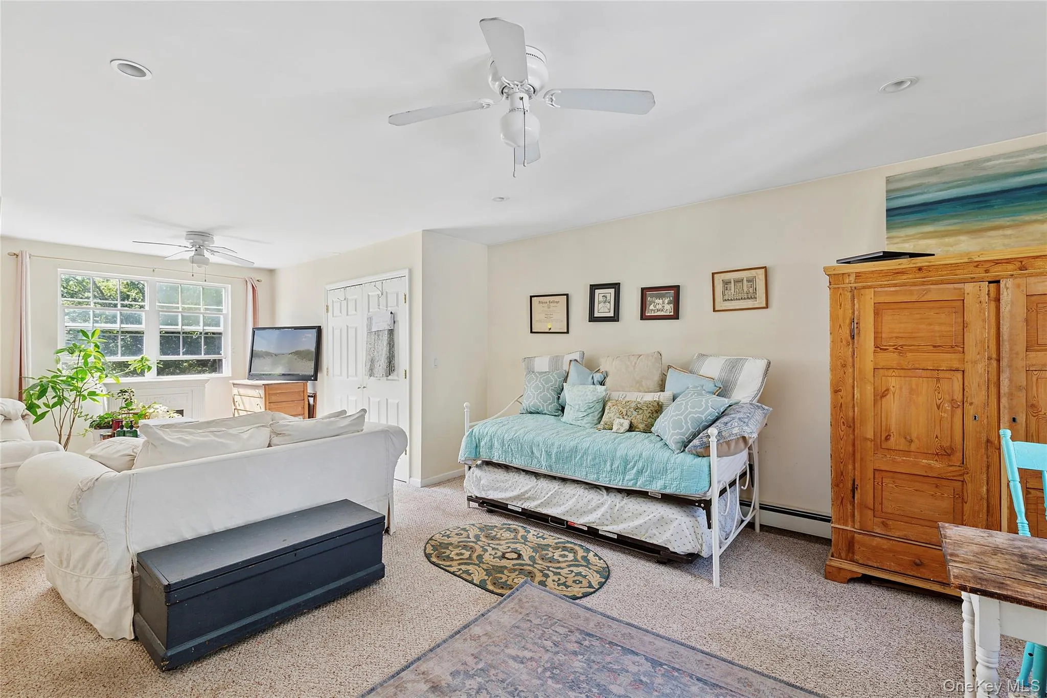 Carpeted living area featuring ceiling fan and a baseboard heating unit Carpeted living area featuring ceiling fan and a baseboard heating unit