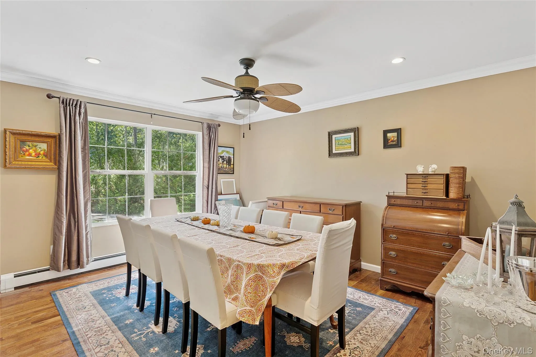 Dining space with crown molding, wood finished floors, a baseboard radiator, ceiling fan, and recessed lighting Dining space with crown molding, wood finished floors, a baseboard radiator, ceiling fan, and recessed lighting