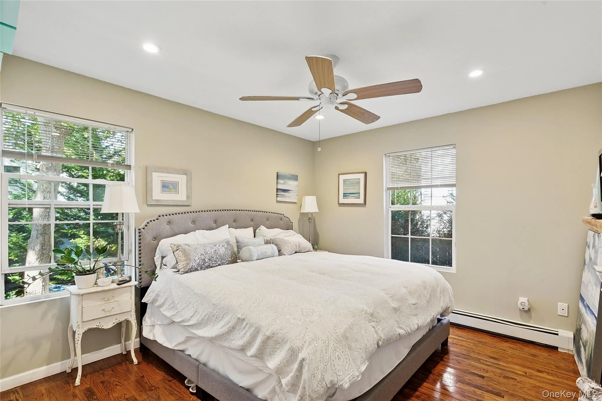 Bedroom featuring a baseboard radiator, dark wood-style floors, recessed lighting, and a ceiling fan Bedroom featuring a baseboard radiator, dark wood-style floors, recessed lighting, and a ceiling fan
