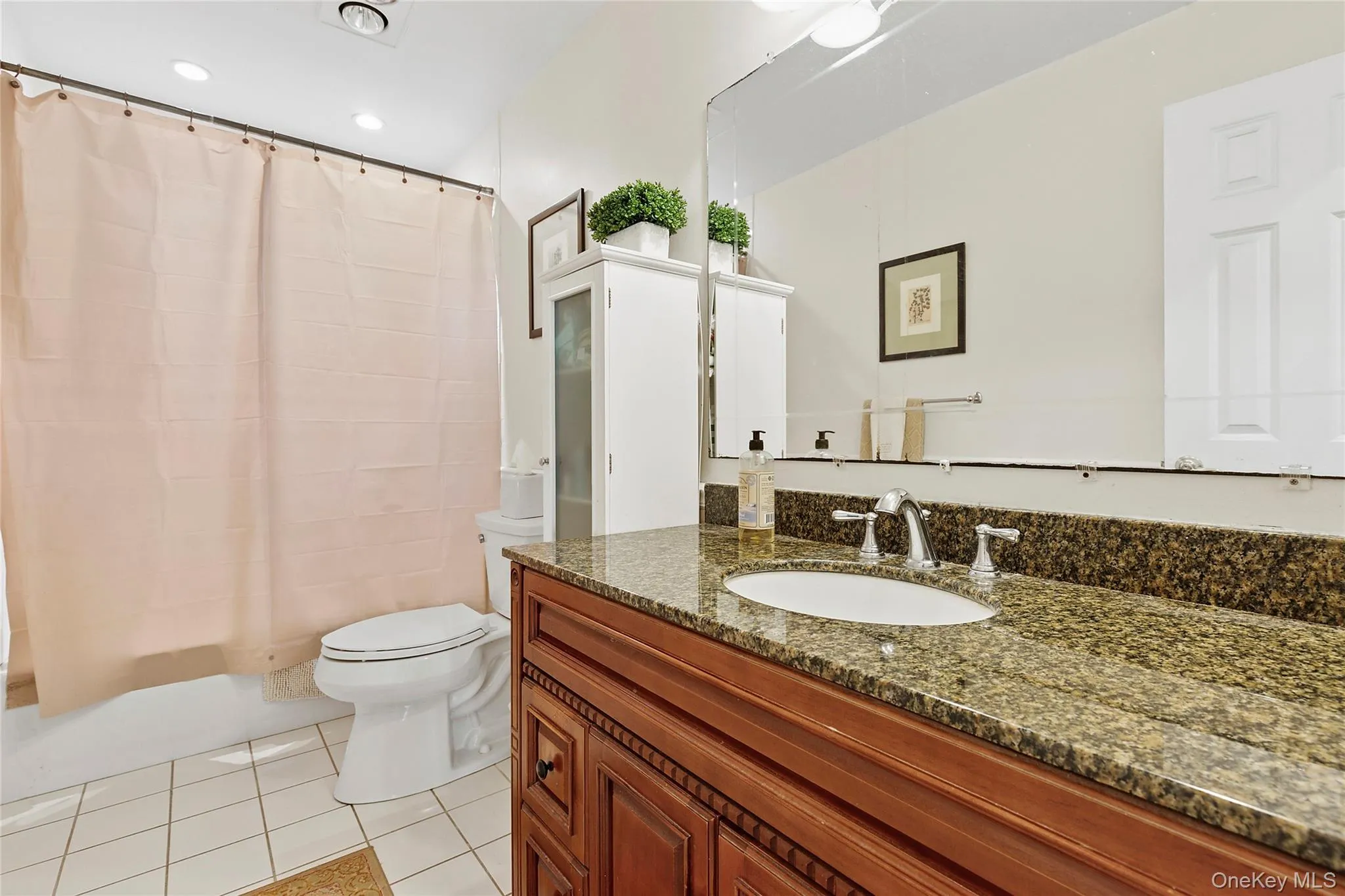 Full bath featuring light tile patterned floors, vanity, shower / bath combo, and recessed lighting Full bath featuring light tile patterned floors, vanity, shower / bath combo, and recessed lighting