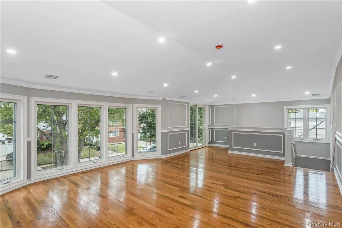 Unfurnished living room with crown molding, light wood-type flooring, a decorative wall, and recessed lighting Unfurnished living room with crown molding, light wood-type flooring, a decorative wall, and recessed lighting
