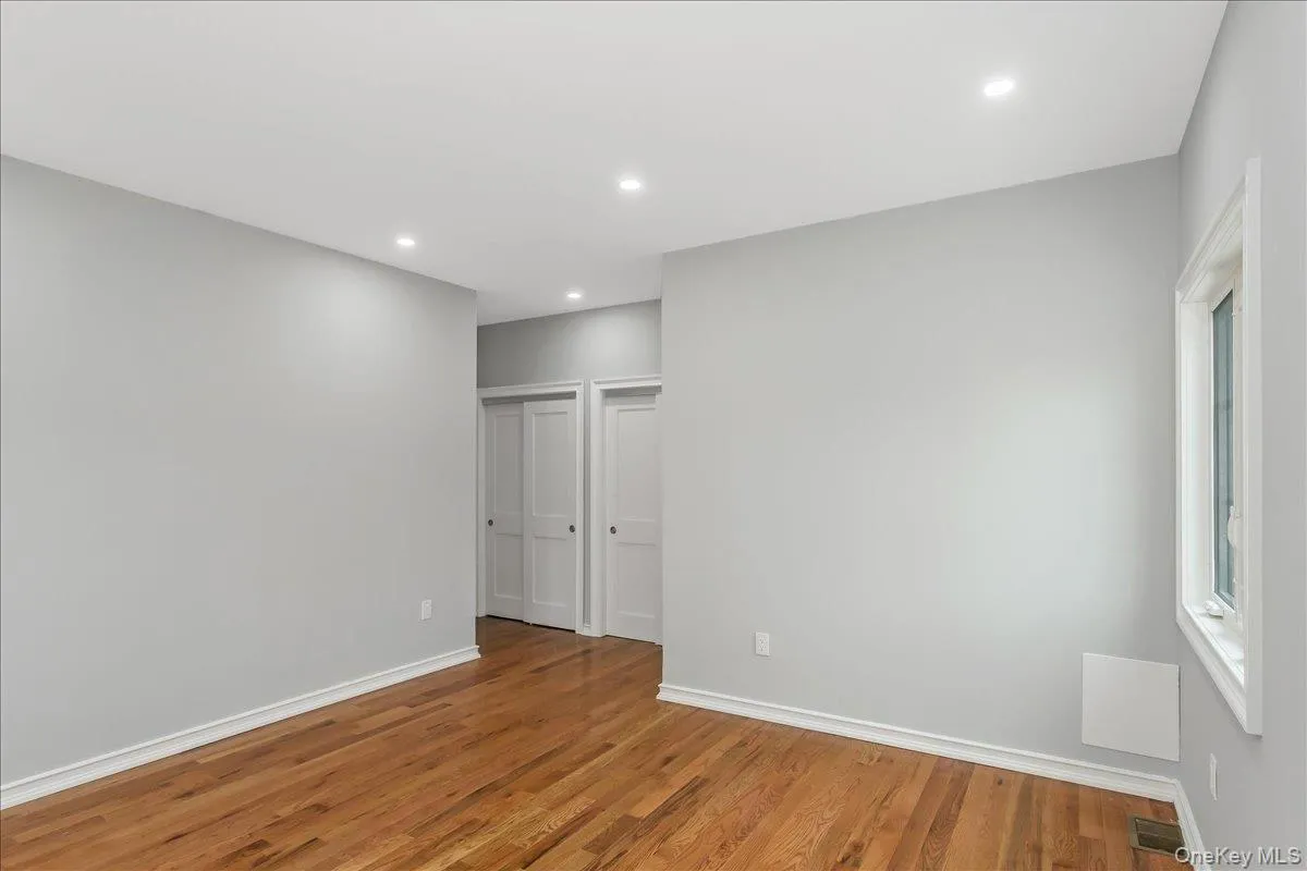 Unfurnished bedroom featuring wood finished floors, recessed lighting, and multiple closets Unfurnished bedroom featuring wood finished floors, recessed lighting, and multiple closets