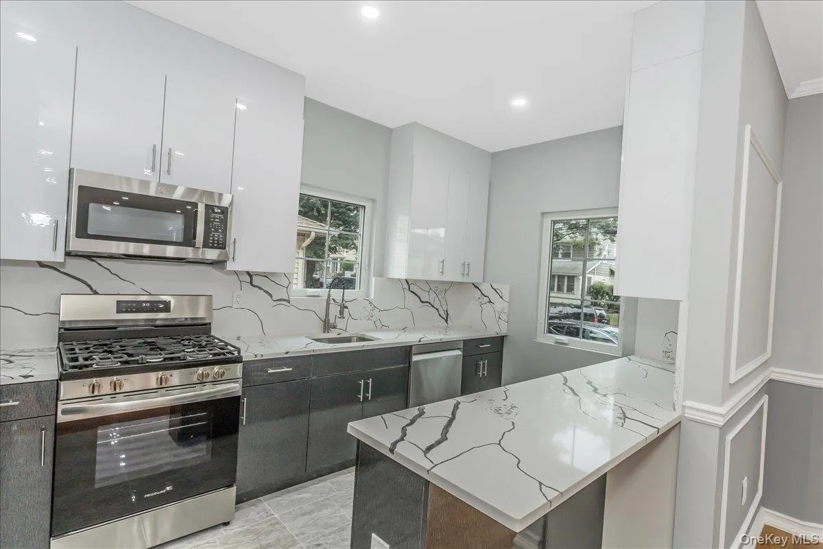 Kitchen featuring stainless steel appliances, light stone countertops, white cabinets, backsplash, and recessed lighting Kitchen featuring stainless steel appliances, light stone countertops, white cabinets, backsplash, and recessed lighting
