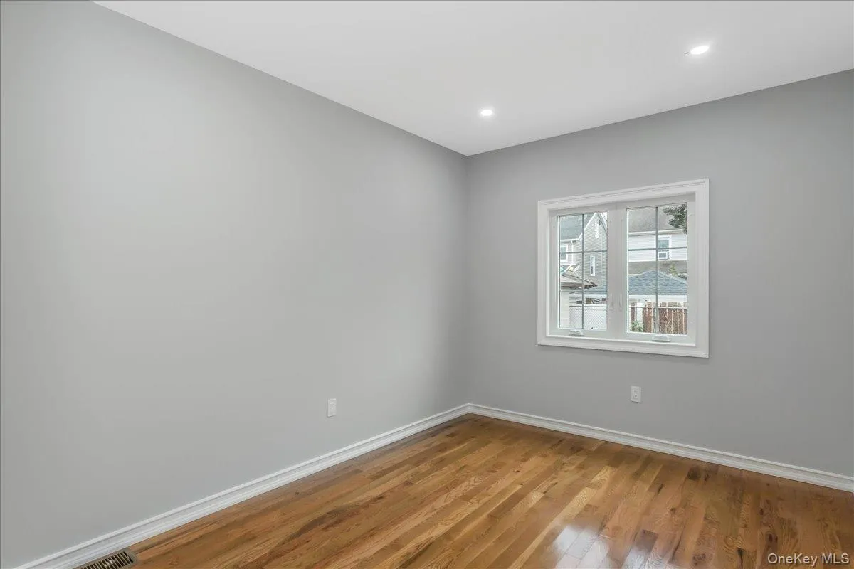 Empty room with wood finished floors and recessed lighting Empty room with wood finished floors and recessed lighting