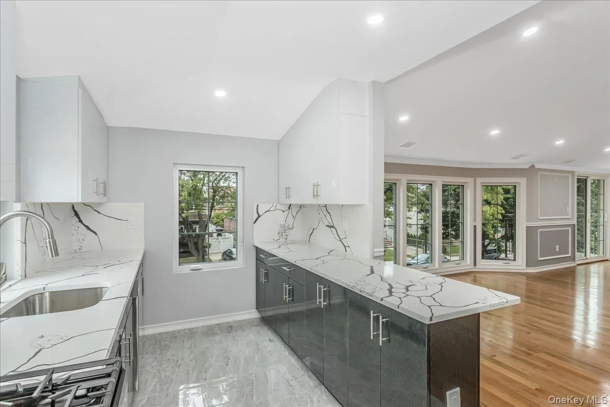 Kitchen featuring light stone counters, white cabinets, modern cabinets, and recessed lighting Kitchen featuring light stone counters, white cabinets, modern cabinets, and recessed lighting
