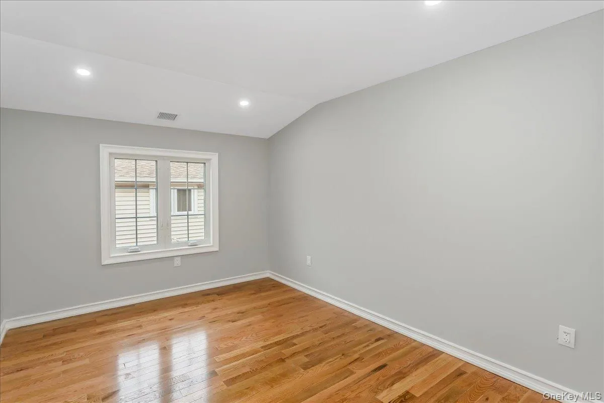 Unfurnished room with recessed lighting, light wood finished floors, and lofted ceiling Unfurnished room with recessed lighting, light wood finished floors, and lofted ceiling