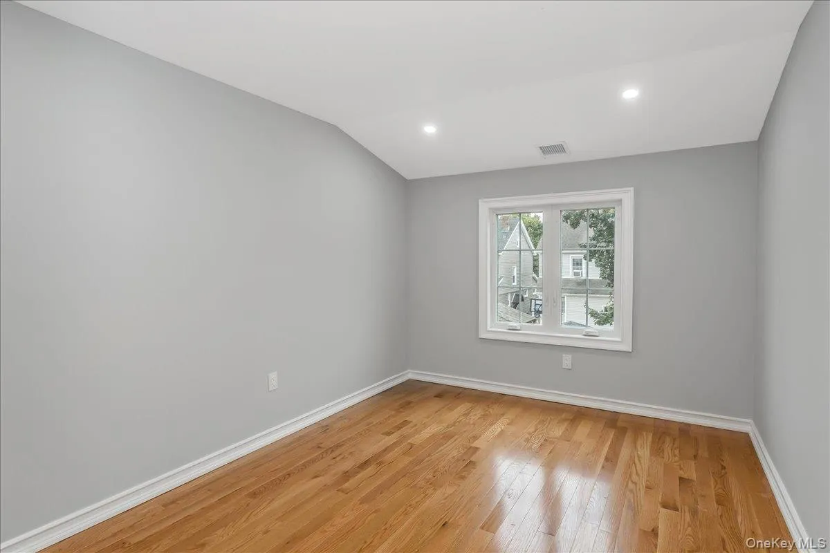 Unfurnished room featuring light wood-type flooring, recessed lighting, and vaulted ceiling Unfurnished room featuring light wood-type flooring, recessed lighting, and vaulted ceiling