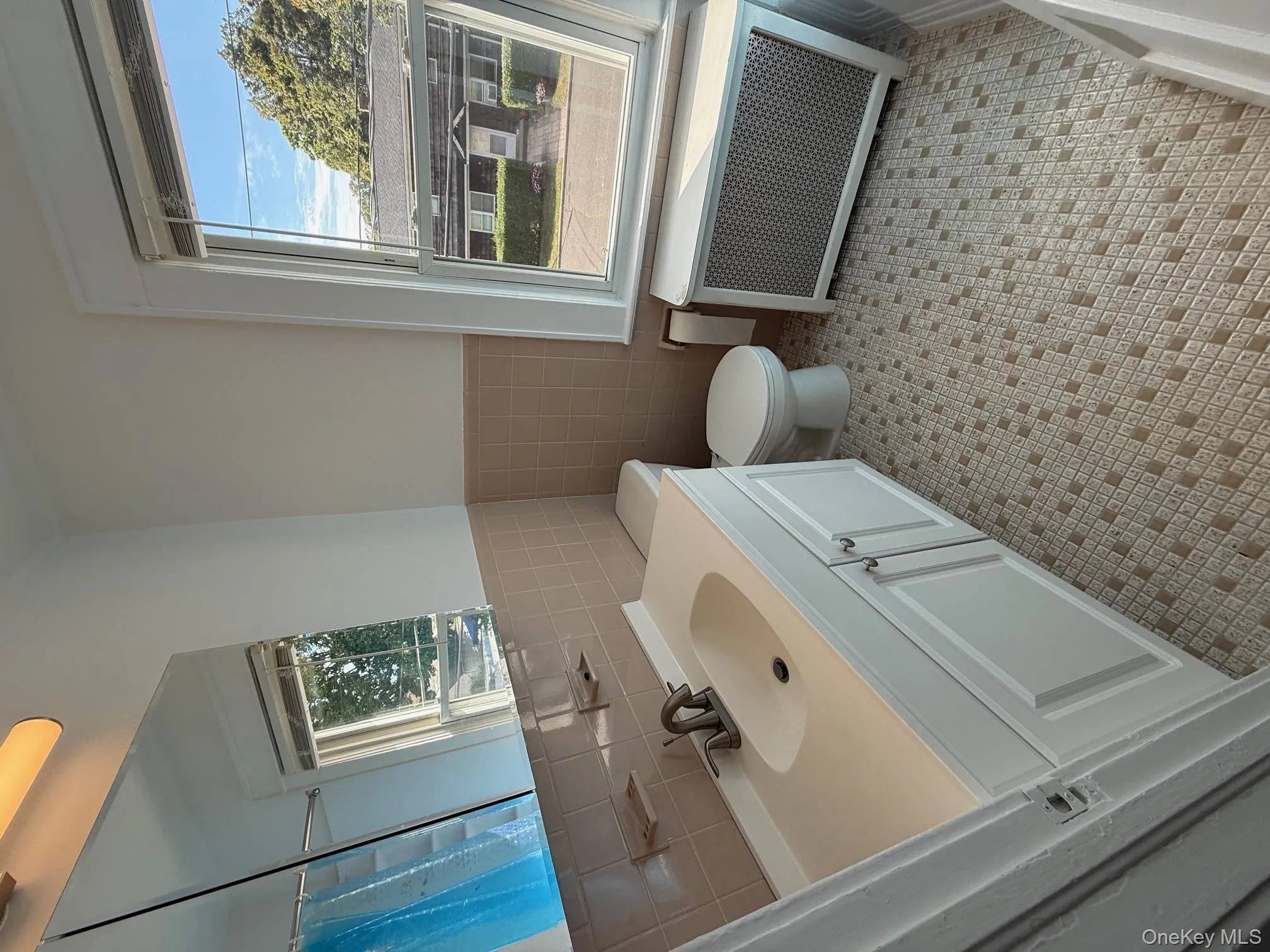 Full bath featuring radiator heating unit, vanity, tile walls, wainscoting, and a shower with curtain Full bath featuring radiator heating unit, vanity, tile walls, wainscoting, and a shower with curtain