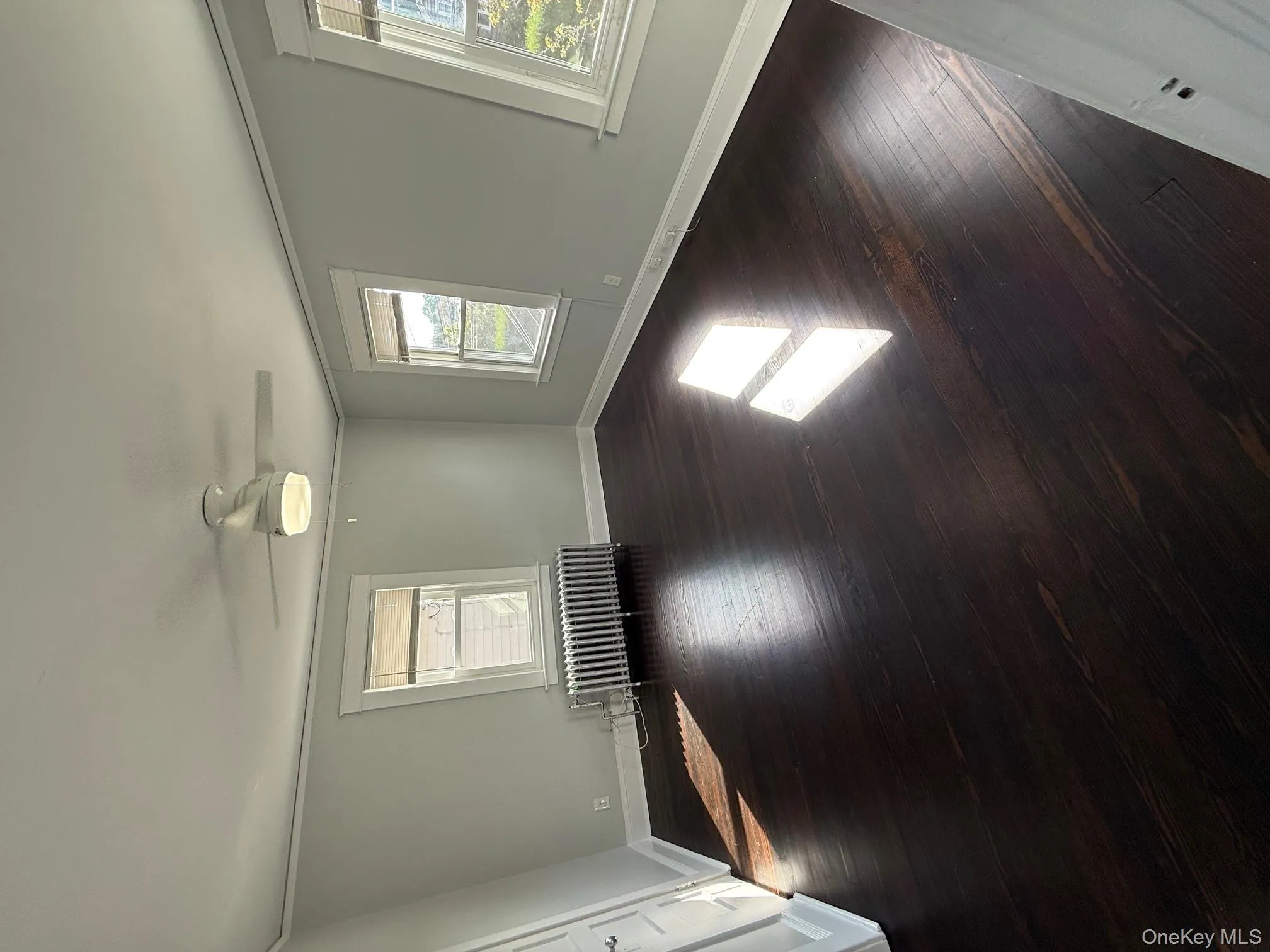 Spare room with dark wood finished floors, radiator, ornamental molding, and a ceiling fan Spare room with dark wood finished floors, radiator, ornamental molding, and a ceiling fan